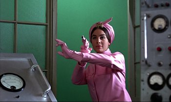 Movie still from “Help!” (1965), directed by Richard Lester – A woman in a pink dress and a pink head scarf; Medium shot, Low angle