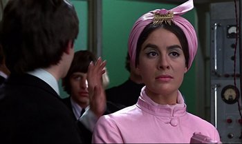 Movie still from “Help!” (1965), directed by Richard Lester – A woman in a pink dress and a pink turban; Close Up shot, Low angle