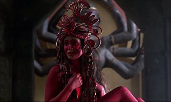 Movie still from “Help!” (1965), directed by Richard Lester – A woman with red makeup and a red headpiece; Medium shot, Low angle