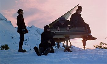 Movie still from “Help!” (1965), directed by Richard Lester – A group of people sitting on top of a snow covered slope; Wide shot, Low angle