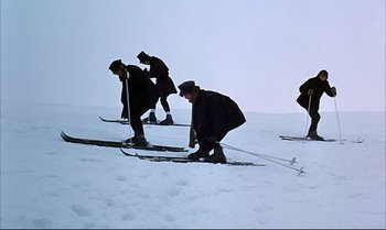 Movie still from “Help!” (1965), directed by Richard Lester – A group of people riding skis on top of a snow covered slope; Wide shot, Low angle