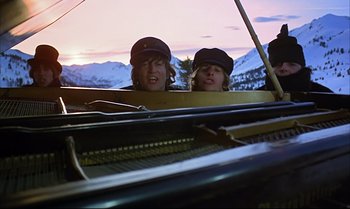 Movie still from “Help!” (1965), directed by Richard Lester – Two young people are sitting in front of a piano; Wide shot, Low angle