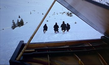 Movie still from “Help!” (1965), directed by Richard Lester – A group of people sitting on top of a snow covered piano; Extreme Wide shot, High angle