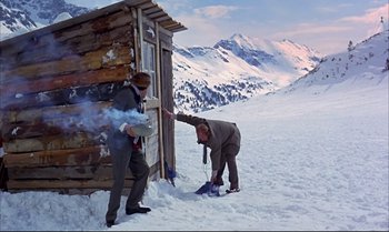 Movie still from “Help!” (1965), directed by Richard Lester – Two men in the snow near an old cabin; Wide shot, High angle