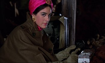 Movie still from “Help!” (1965), directed by Richard Lester – A woman wearing a pink turban and a brown coat; Close Up shot, Low angle