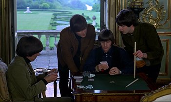 Movie still from “Help!” (1965), directed by Richard Lester – A group of people sitting at a table playing cards; Medium shot, High angle