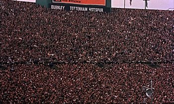 Movie still from “Help!” (1965), directed by Richard Lester – A large crowd of people are gathered in a stadium; Extreme Wide shot, High angle
