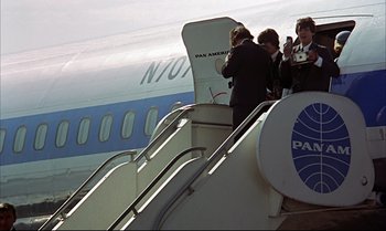 Movie still from “Help!” (1965), directed by Richard Lester – A group of people standing on the stairs of an airplane; Wide shot, Low angle