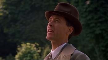 Movie still from “Henry & June” (1990), directed by Philip Kaufman – A person wearing a suit and a hat; Close Up shot, Low angle