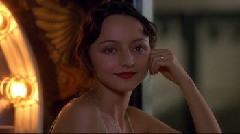 Movie still from “Henry & June” (1990), directed by Philip Kaufman – A beautiful woman with red lipstick posing for a picture; Close Up shot, Over the shoulder angle