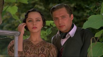 Movie still from “Henry & June” (1990), directed by Philip Kaufman – A man and a woman standing next to each other in front of trees; Close Up shot, Low angle