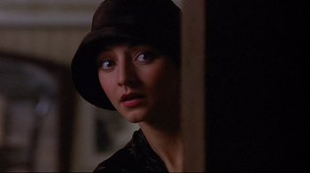 Movie still from “Henry & June” (1990), directed by Philip Kaufman – A woman wearing a brown hat looking at the camera; Close Up shot, Over the shoulder angle