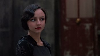 Movie still from “Henry & June” (1990), directed by Philip Kaufman – A woman with dark hair wearing a black dress; Close Up shot, Over the shoulder angle