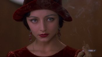 Movie still from “Henry & June” (1990), directed by Philip Kaufman – A person wearing a hat and earrings; Close Up shot, Over the shoulder angle