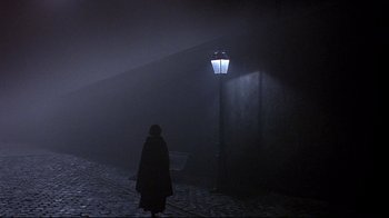 Movie still from “Henry & June” (1990), directed by Philip Kaufman – A person standing in front of a street light; Extreme Wide shot, Over the shoulder angle
