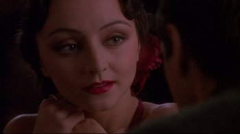 Movie still from “Henry & June” (1990), directed by Philip Kaufman – A person with a flower in their hair; Close Up shot, Over the shoulder angle