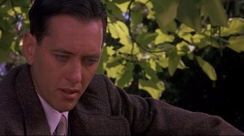 Movie still from “Henry & June” (1990), directed by Philip Kaufman – A person wearing a suit and tie; Close Up shot, Over the shoulder angle