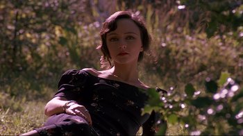 Movie still from “Henry & June” (1990), directed by Philip Kaufman – A woman in a black dress in the grass; Medium shot, High angle