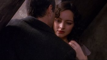 Movie still from “Henry & June” (1990), directed by Philip Kaufman – A man and a woman embracing each other in front of a stone wall; Close Up shot, Over the shoulder angle