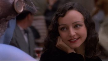 Movie still from “Henry & June” (1990), directed by Philip Kaufman – A person sitting at a table with other people; Close Up shot, High angle