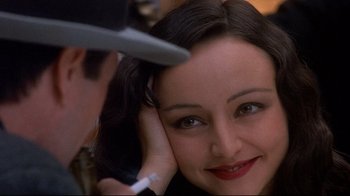 Movie still from “Henry & June” (1990), directed by Philip Kaufman – A woman sitting in front of a man with a hat on; Close Up shot, Over the shoulder angle