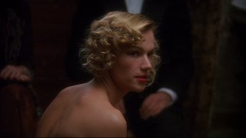 Movie still from “Henry & June” (1990), directed by Philip Kaufman – A woman with blonde curly hair and a red lipstick; Close Up shot, Over the shoulder angle