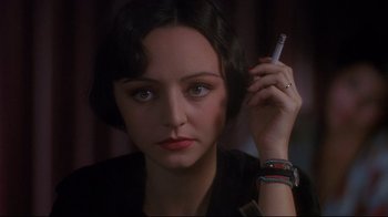 Movie still from “Henry & June” (1990), directed by Philip Kaufman – A woman holding a cigarette in her right hand; Close Up shot, Over the shoulder angle
