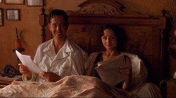 Movie still from “Henry & June” (1990), directed by Philip Kaufman – A man and a woman sitting on a bed; Medium shot, High angle