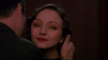 Movie still from “Henry & June” (1990), directed by Philip Kaufman – A woman with red lipstick is posing for a picture; Close Up shot, Over the shoulder angle