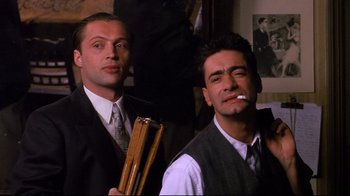 Movie still from “Henry & June” (1990), directed by Philip Kaufman – A couple of men standing next to each other in a room; Medium shot, Low angle