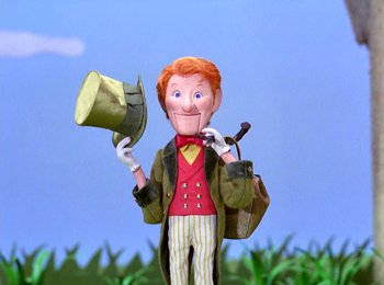 Movie still from “Here Comes Peter Cottontail” (1971), directed by Jules Bass – A toy figure of a man holding a top hat; Medium shot, Low angle