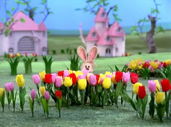 Movie still from “Here Comes Peter Cottontail” (1971), directed by Jules Bass – An easter bunny in a field of flowers; Wide shot, Low angle