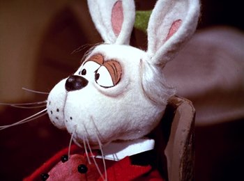 Movie still from “Here Comes Peter Cottontail” (1971), directed by Jules Bass – A stuffed animal of a rabbit wearing a red suit; Close Up shot, High angle