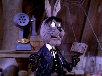 Movie still from “Here Comes Peter Cottontail” (1971), directed by Jules Bass – A toy rabbit wearing a suit and tie; Medium shot, High angle
