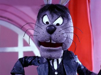 Movie still from “Here Comes Peter Cottontail” (1971), directed by Jules Bass – A stuffed animal wearing a suit and tie; Close Up shot, Low angle