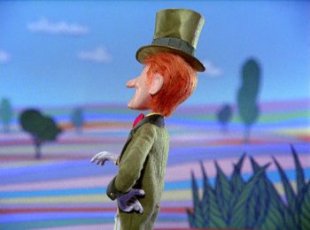 Movie still from “Here Comes Peter Cottontail” (1971), directed by Jules Bass – A cartoon character wearing a green suit and a green hat; Medium shot, Low angle