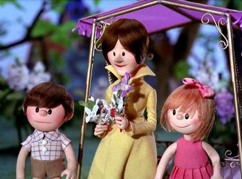 Movie still from “Here Comes Peter Cottontail” (1971), directed by Jules Bass – A woman and two small children standing next to her; Medium shot, Low angle
