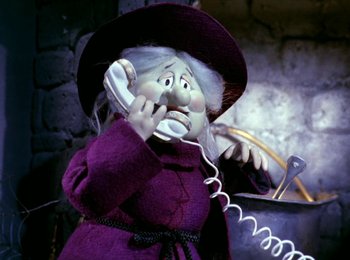 Movie still from “Here Comes Peter Cottontail” (1971), directed by Jules Bass – A doll is talking on a phone while wearing a purple outfit; Close Up shot, Low angle