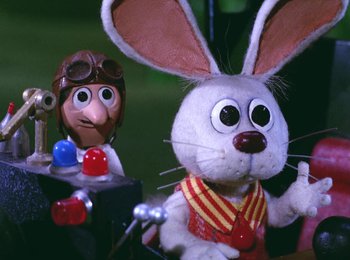 Movie still from “Here Comes Peter Cottontail” (1971), directed by Jules Bass – A stuffed rabbit next to a stuffed doll; Close Up shot, Low angle