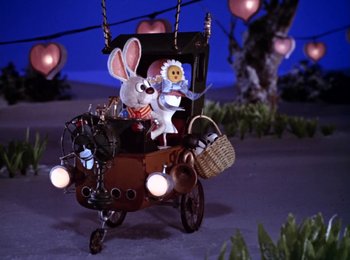 Movie still from “Here Comes Peter Cottontail” (1971), directed by Jules Bass – A toy rabbit sitting on top of a wooden carriage; Wide shot, High angle
