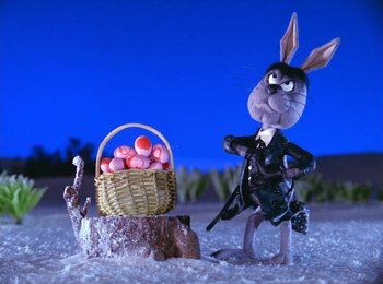 Movie still from “Here Comes Peter Cottontail” (1971), directed by Jules Bass – A toy rabbit with a basket full of eggs; Medium shot, Low angle