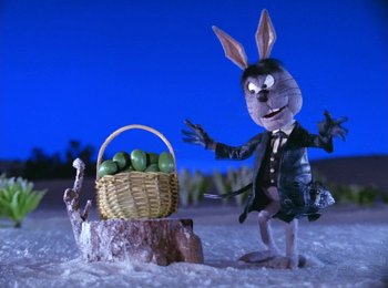 Movie still from “Here Comes Peter Cottontail” (1971), directed by Jules Bass – A bunny rabbit standing next to a basket of apples; Medium shot, Low angle
