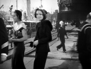 Movie still from “Here Comes the Navy” (1934), directed by Lloyd Bacon – A black and white photo of a group of young people; Medium shot, Over the shoulder angle