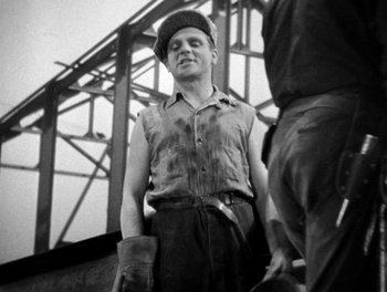 Movie still from “Here Comes the Navy” (1934), directed by Lloyd Bacon – A black and white photo of a man standing next to another man; Medium shot, Low angle