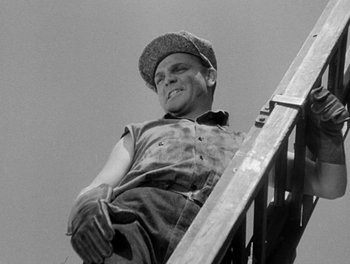 Movie still from “Here Comes the Navy” (1934), directed by Lloyd Bacon – A man sitting on top of a metal stair railing; Medium shot, Low angle