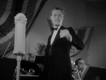 Movie still from “Here Comes the Navy” (1934), directed by Lloyd Bacon – A black and white photo of a man in a tuxedo; Medium shot, Low angle