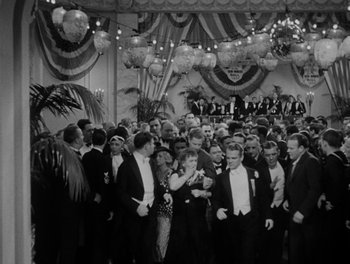 Movie still from “Here Comes the Navy” (1934), directed by Lloyd Bacon – A group of people in tuxedos in front of a crowd; Extreme Wide shot, High angle