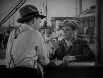 Movie still from “Here Comes the Navy” (1934), directed by Lloyd Bacon – A man in a hat is talking to another man in a hat; Medium shot, Over the shoulder angle