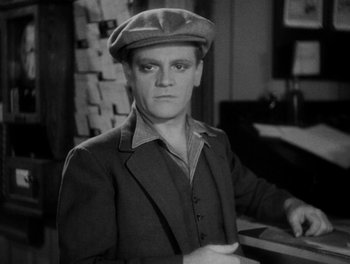 Movie still from “Here Comes the Navy” (1934), directed by Lloyd Bacon – A black and white photo of a man wearing a hat; Close Up shot, High angle