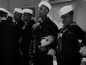 Movie still from “Here Comes the Navy” (1934), directed by Lloyd Bacon – A group of men standing next to each other in uniforms; Medium shot, Low angle